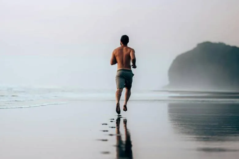 Persona corriendo por la orilla del mar