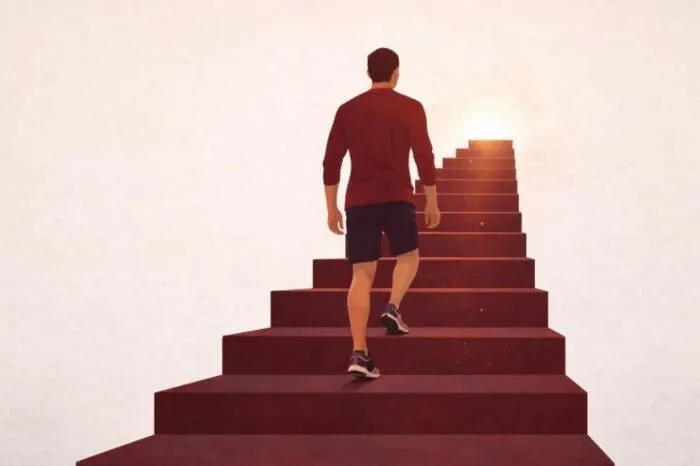 Hombre subiendo una escalera hacia la luz